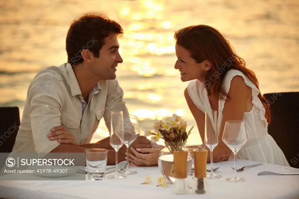 A young couple share a romantic dinner on the beach in the Maldives