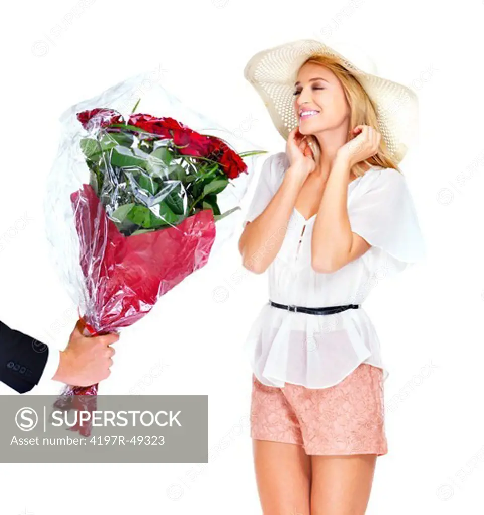 Surprised young woman in a sunhat receiving a bunch of gorgeous roses - isolated on white