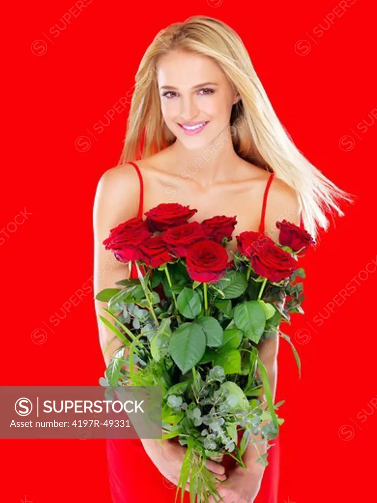 Pretty woman smiling while holding a bunch of red roses - isolated on red
