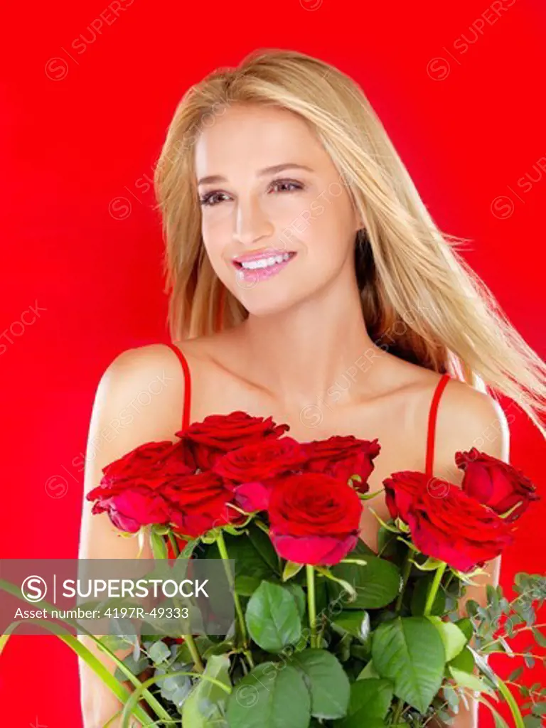 Beautiful woman smiling while holding a bunch of red roses - isolated on red