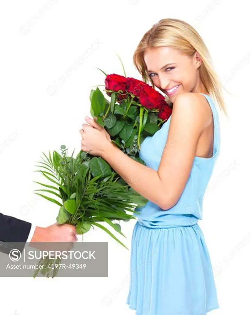 Young woman smiling while cradling a bunch of red roses - isolated