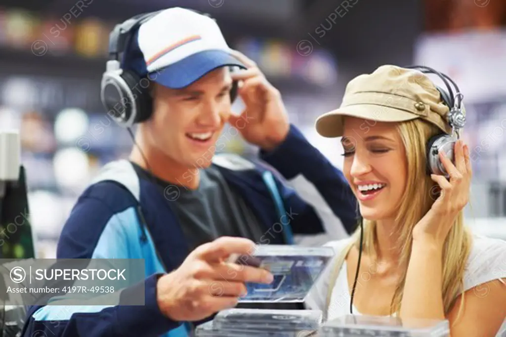 A trendy music-loving couple enjoying songs together at their favourite CD store