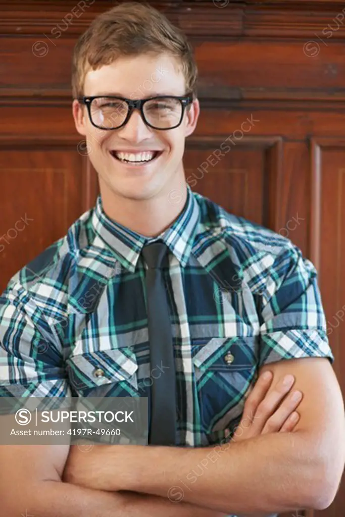 Portrait of smiling fashionable male geek with his arms crossed