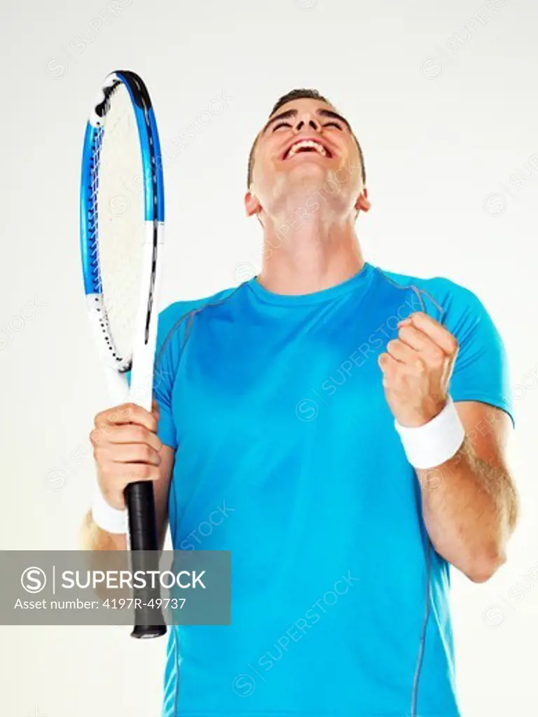Side-view of a young male tennis player celebrating after winning a match
