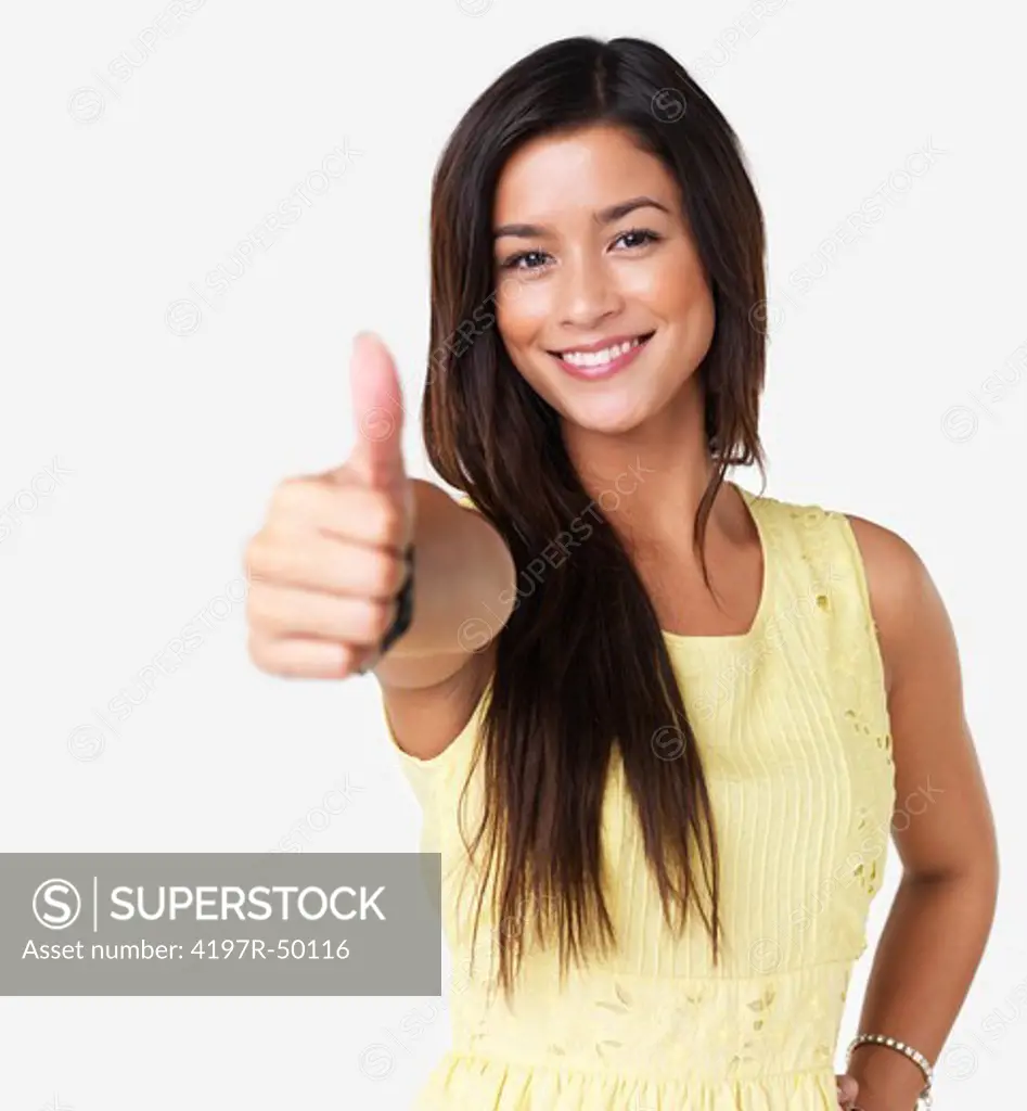 Portrait of a smiling brunette giving you thumbs-up in a summer dress isolated on white