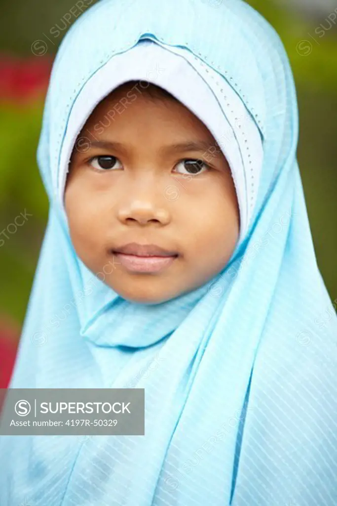 A close-up of a young girl wearing a headscarf