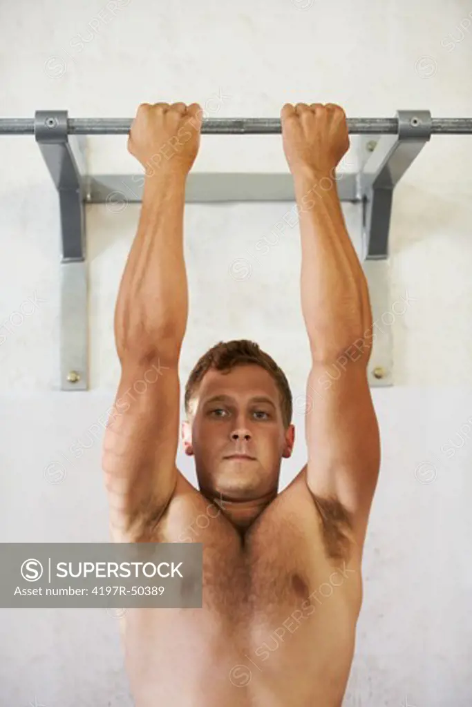 Young caucasian man training in the gym: Narrow-grip front pull-up - Full extention