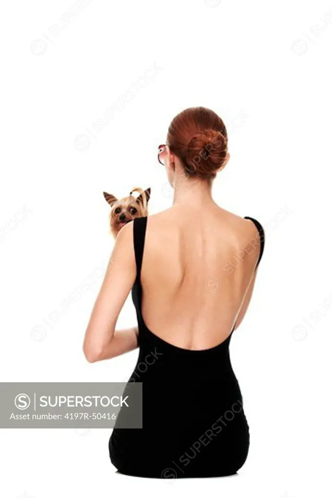 Rearview of a young woman holding a yorkshire terrier - Isolated