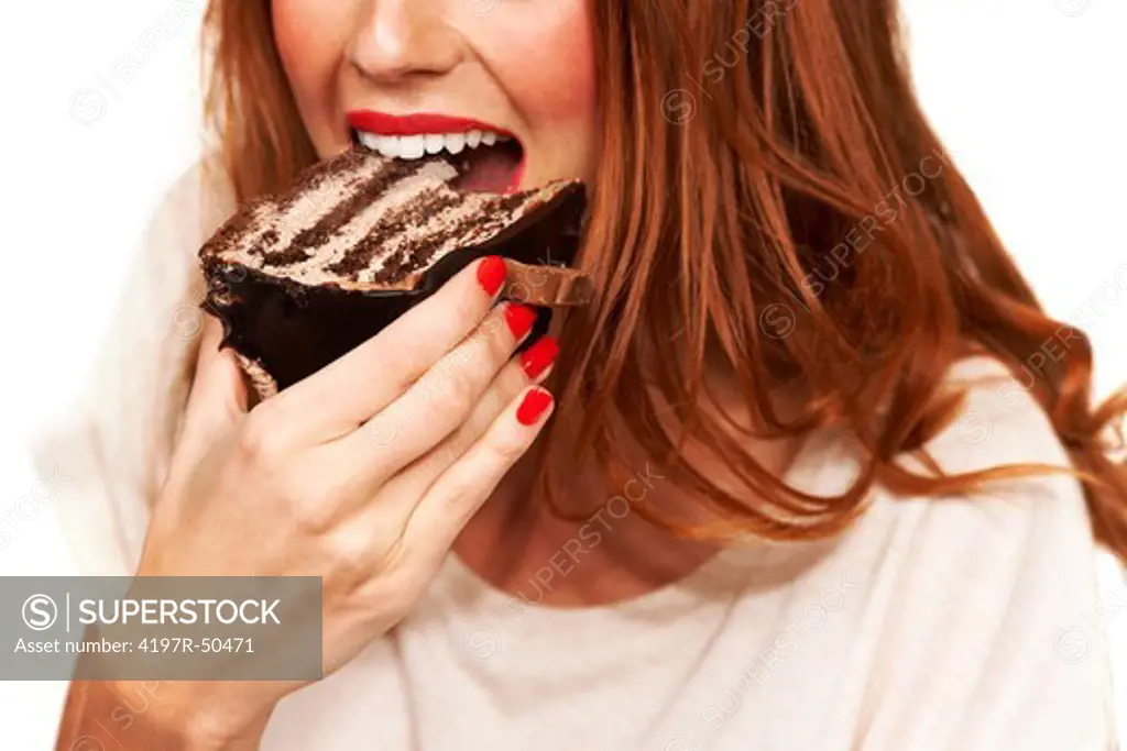 Cropped closeup of a young woman taking a bite from a piece of cake