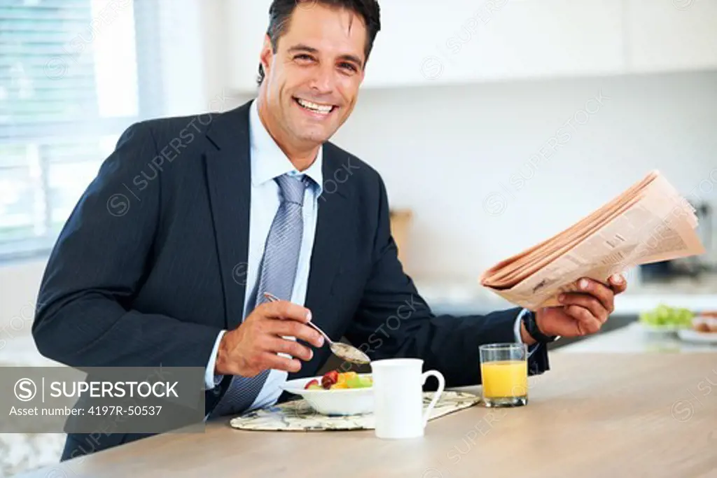 Handsome businessman smiling positively at you while enjoying a healthy breakfast