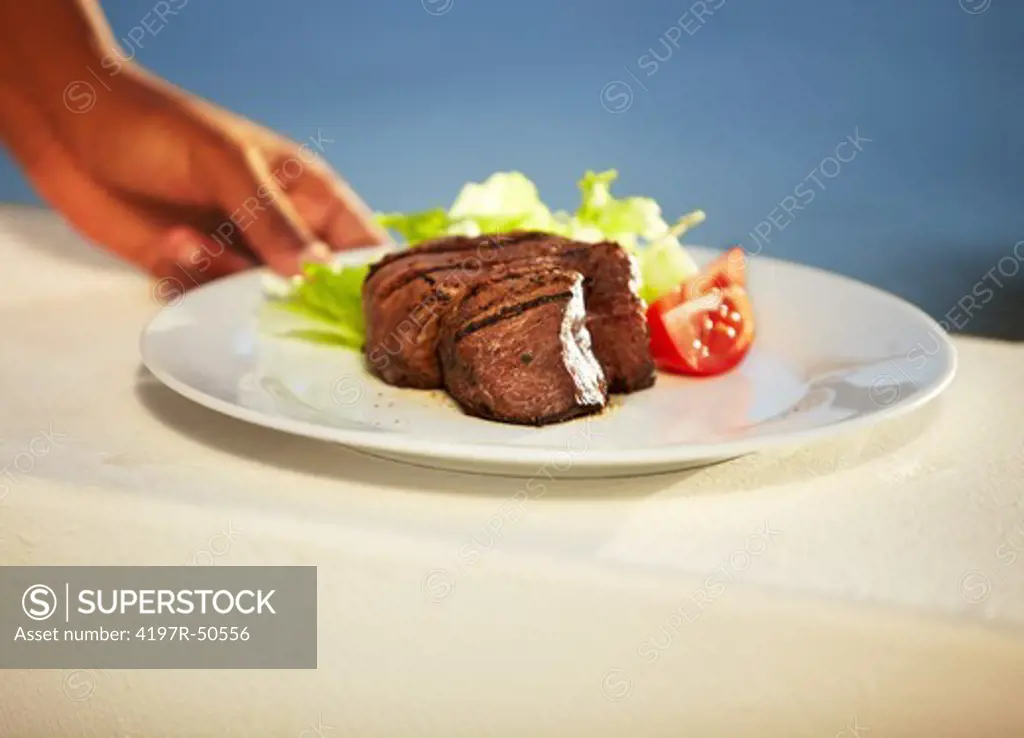 Closeup of a tender and juicy steak being served on a plate
