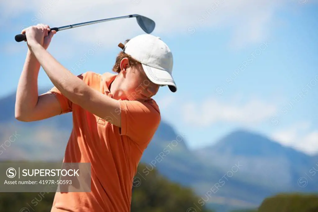 Young golfer getting ready to hit the ball - cropped with copyspace