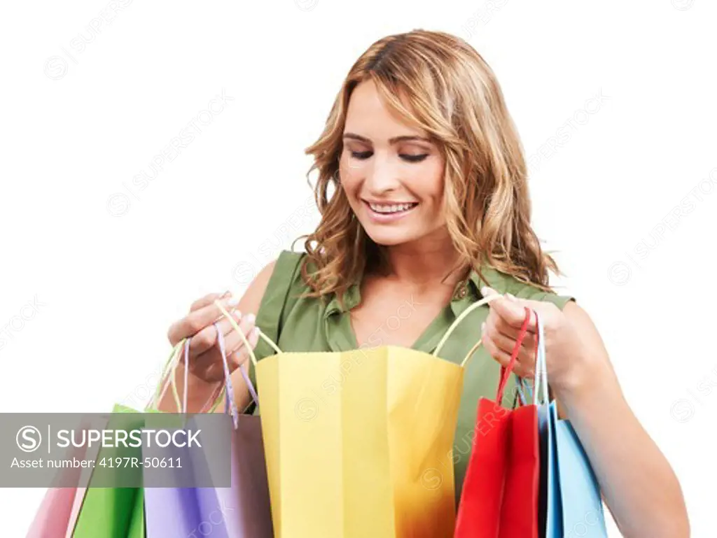 A beautiful woman looking inside her colourful shopping bags and admiring her purchases
