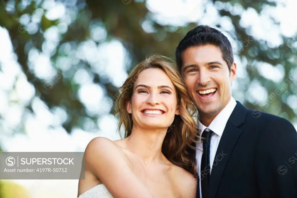 A happy couple laughing together on their wedding day - Copyspace