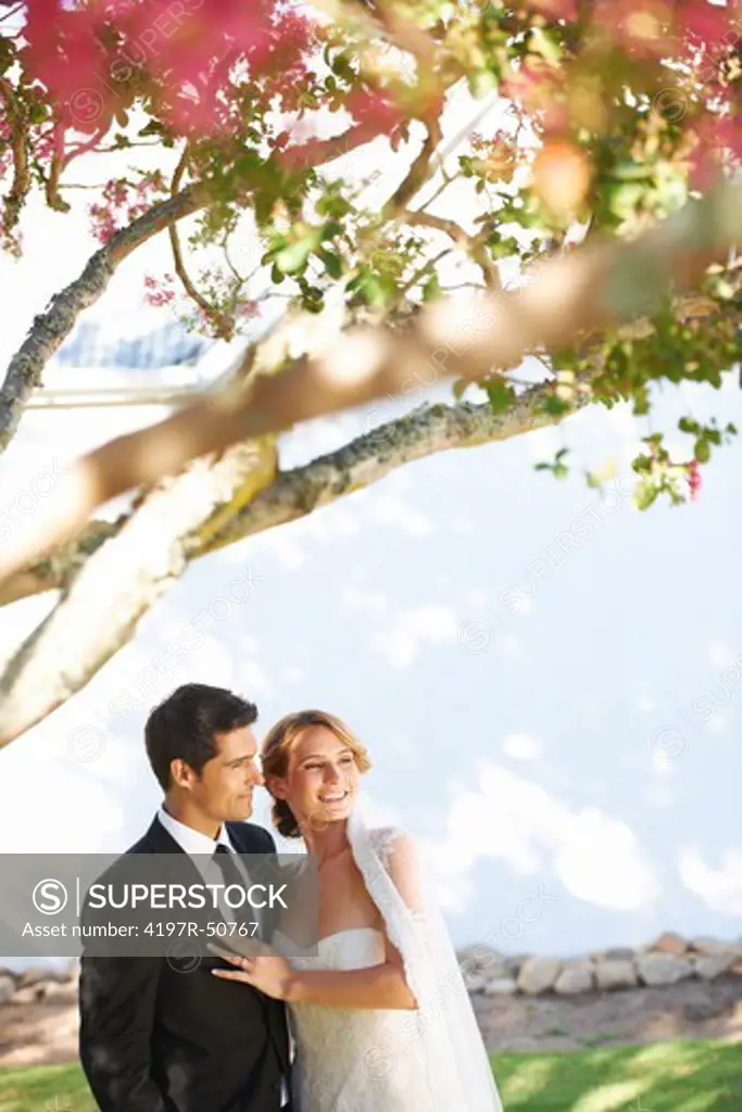 Happy young bride standing with her handsome groom on their wedding day - Copyspace