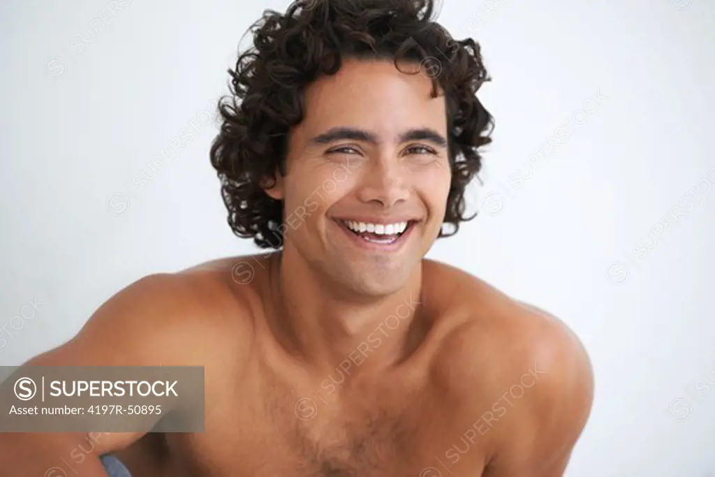 Gorgeous young man smiling at you without a shirt