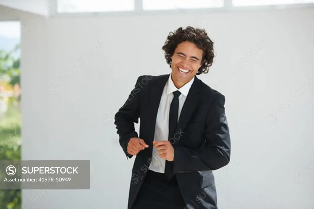 Confident young businessman smiling and laughing while doing a dance
