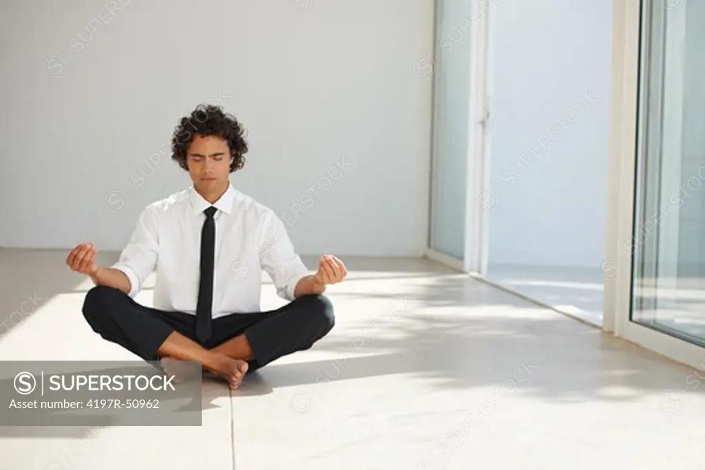 Cropped image of a businessman sitting cross-legged in a meditative pose