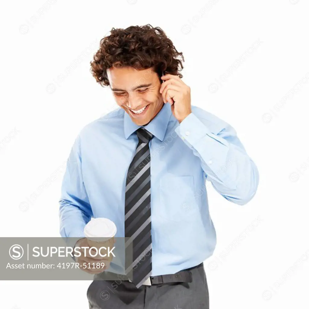 Young successful businessman taking a phone call while holding a coffee - Isolated on white