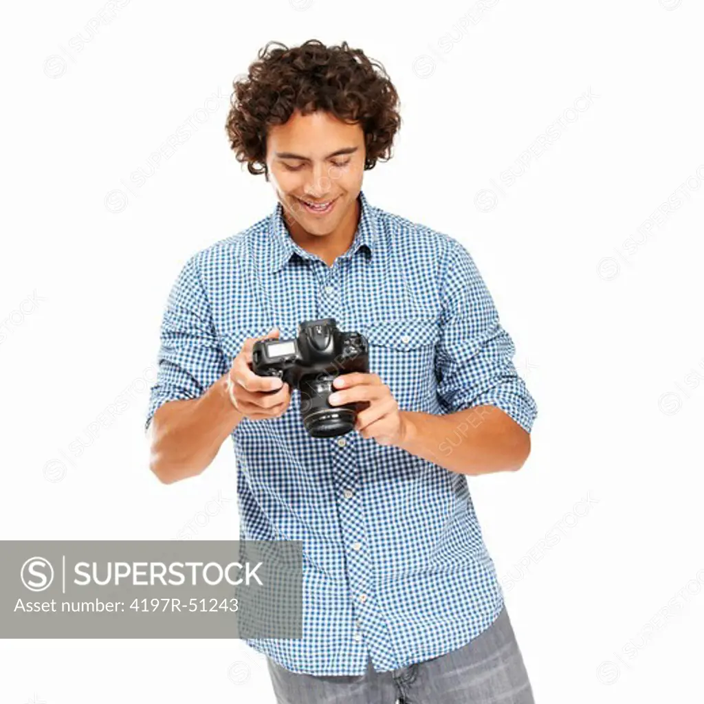 Young man holding his camera and looking at its display after shooting