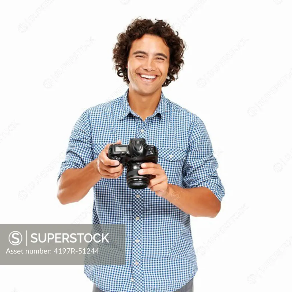 Young man holding his camera and smiling at you - Isolated on white