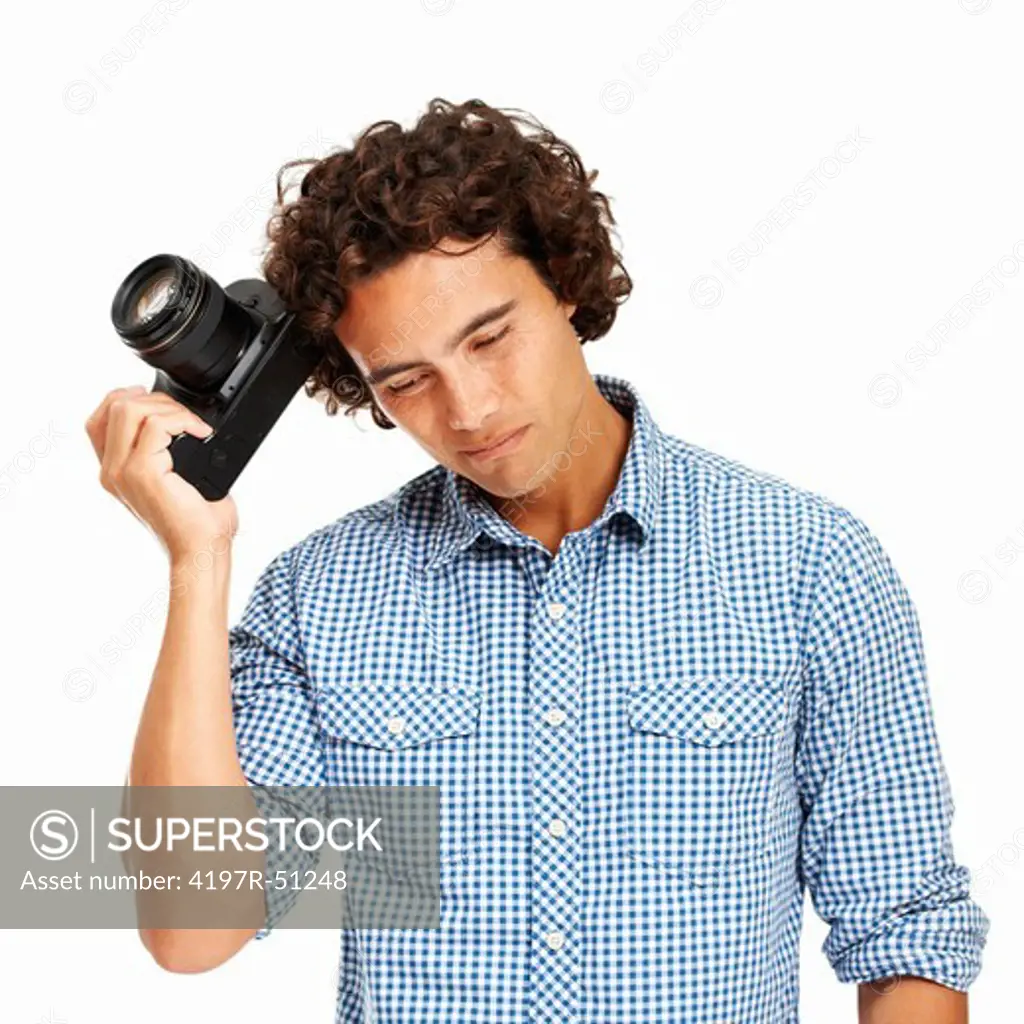 Frustrated young photographer holding his camera to his head - Isolated on white