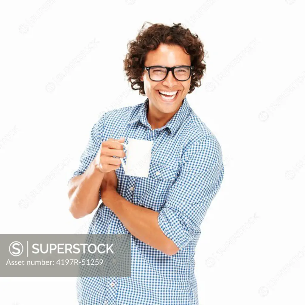 Casual young man with glasses on while holding a mug while isolated on white