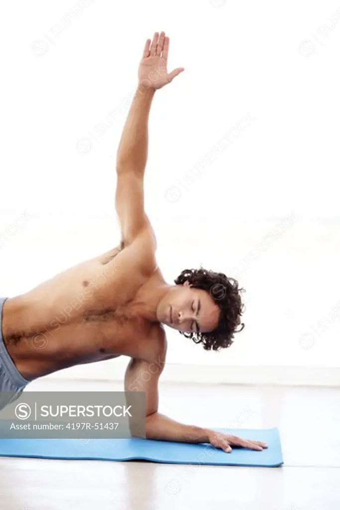 A healthy young man in the side plank yoga pose - Vasisthasana