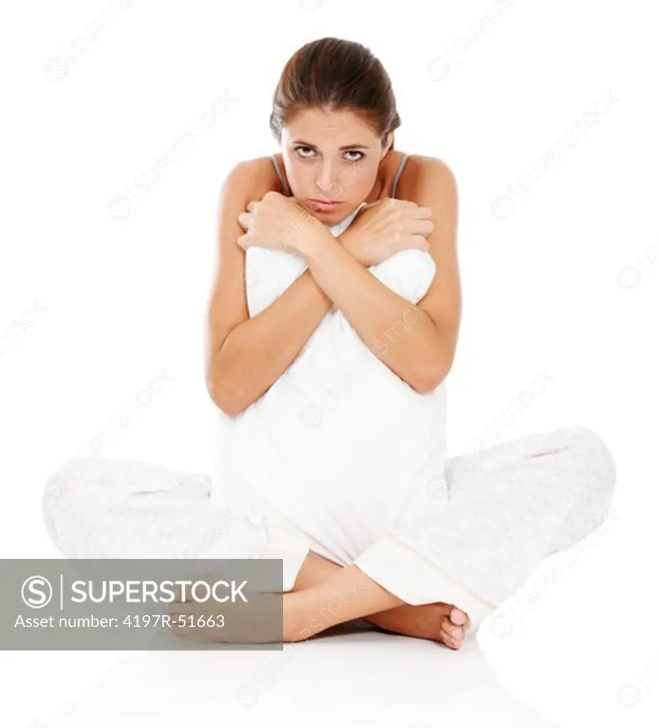 Portrait of an unhappy young woman sitting with her pillow on the floor