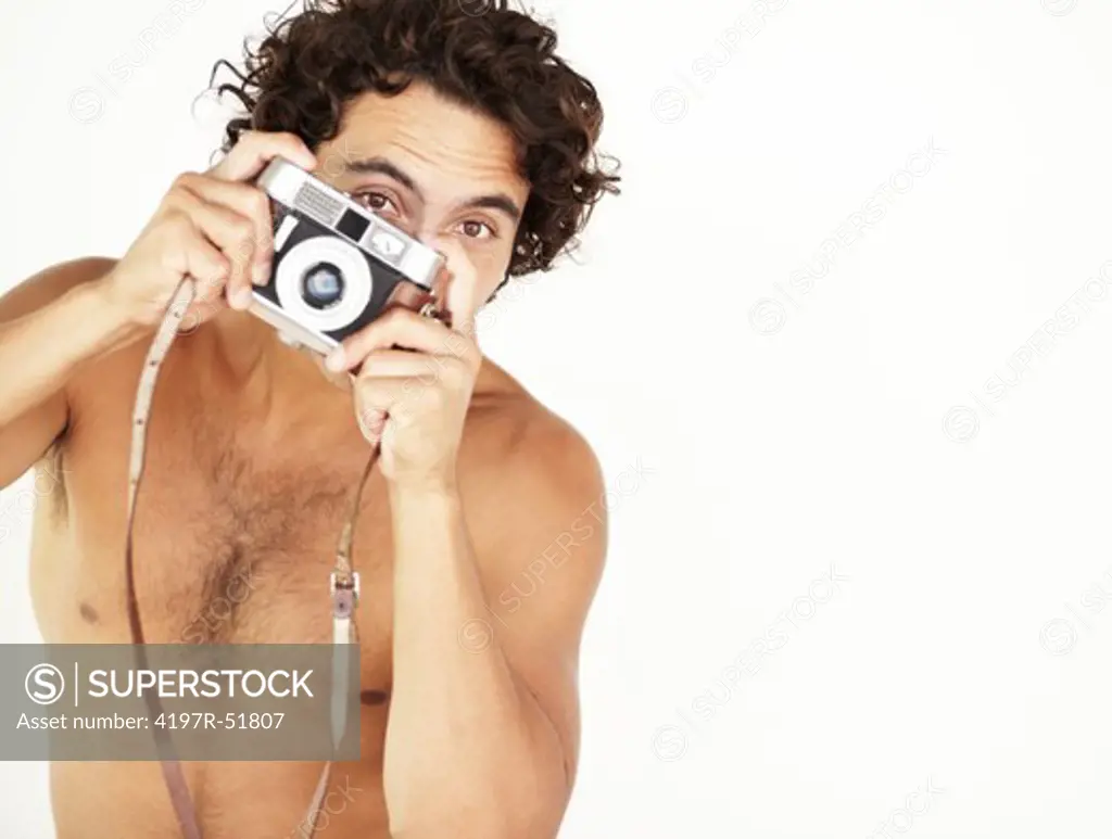 Portrait of a handsome young shirtless man holding a vintage camera