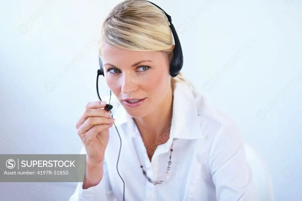 Young call center agent wearing a headset and responding to a client - portrait