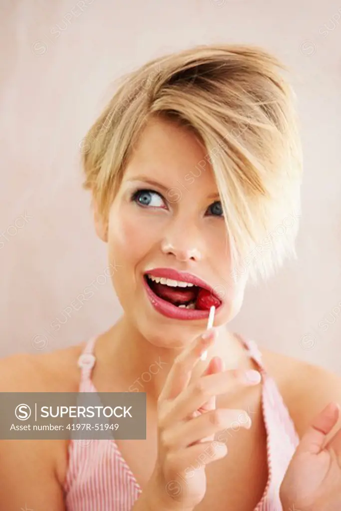 A young blonde woman sucking a lollipop