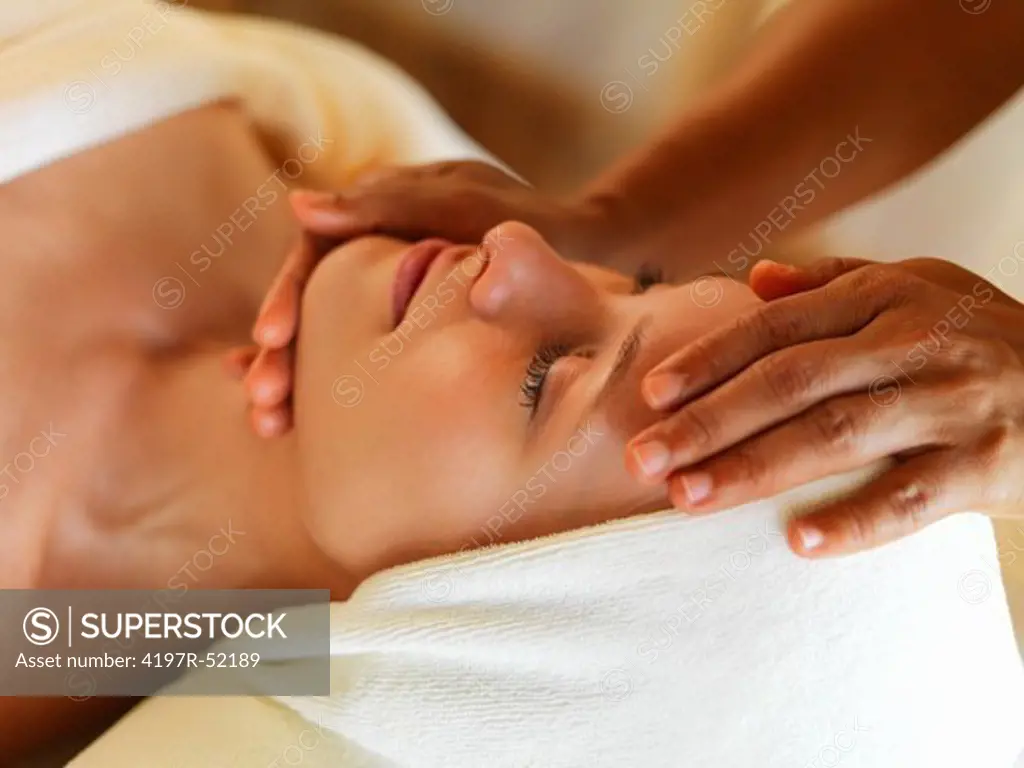 Closeup of beautiful middle aged woman receiving massage at spa