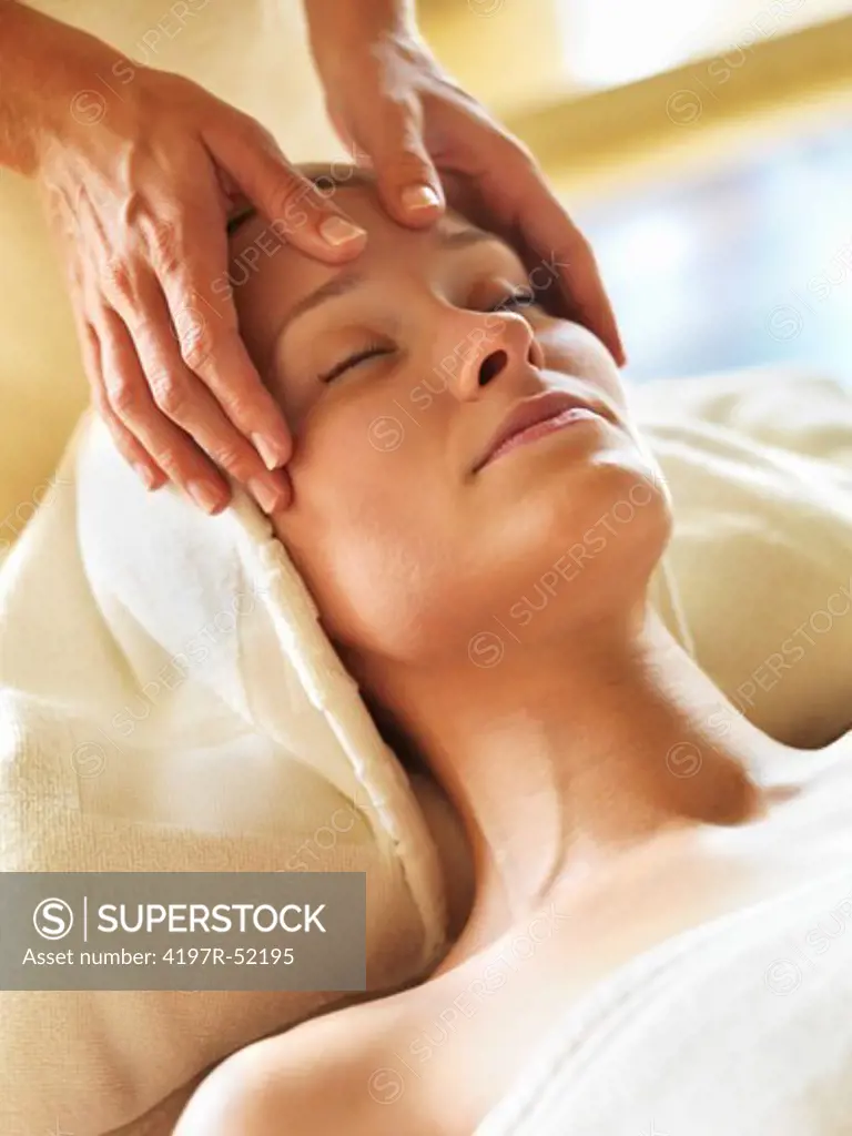 Closeup of beautiful middle aged woman receiving head massage at spa