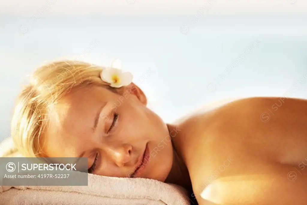 Closeup of attractive middle aged woman relaxing on massage table at spa resort