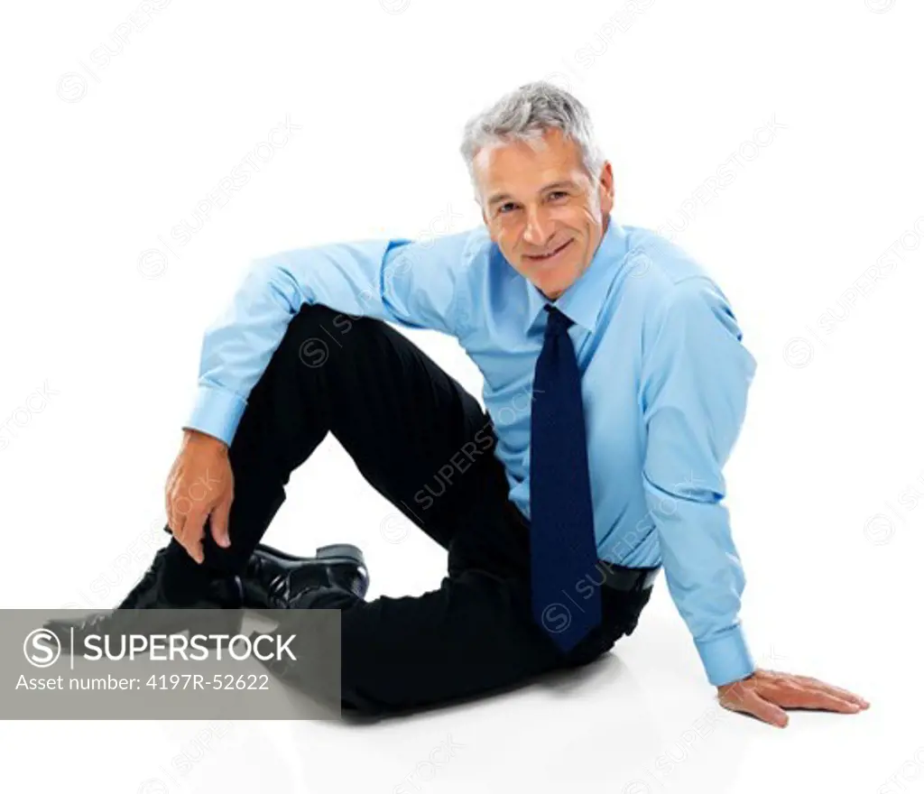 Prtrait of happy senior businessman sitting relaxed on floor over white background