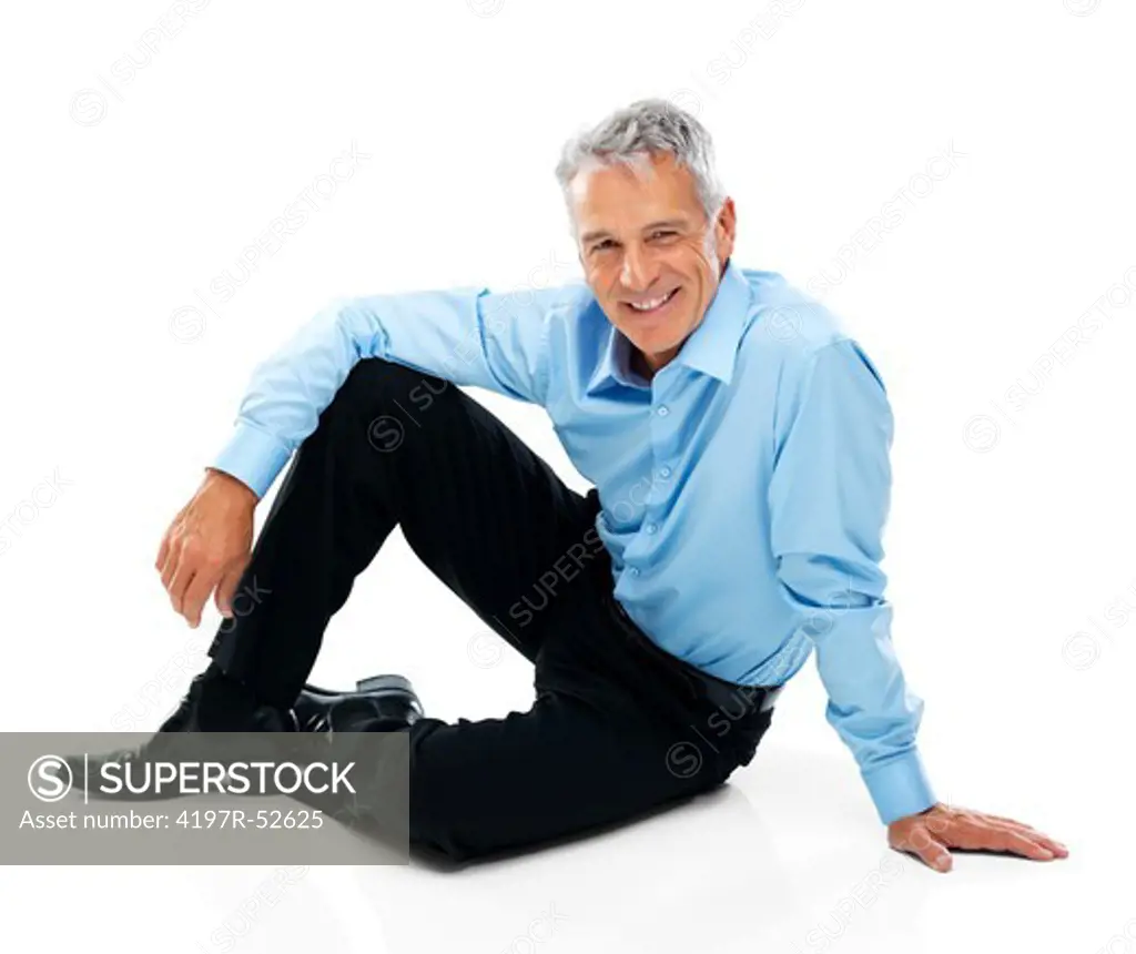 Portrait of senior male executive sitting on floor isolated on white background