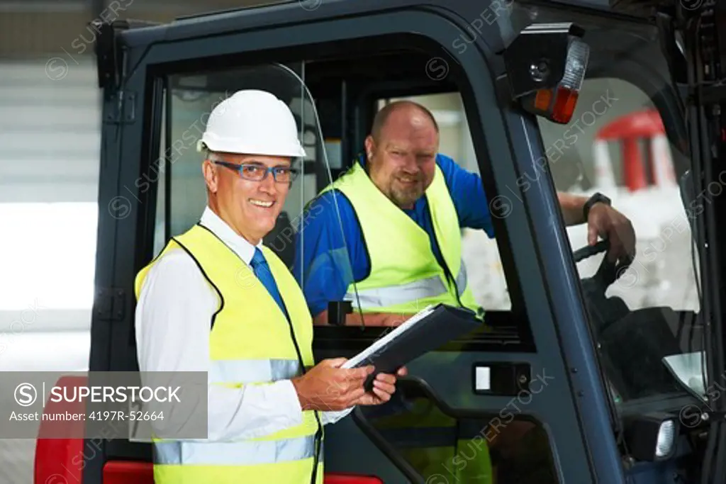 Mature depot forman talking to the forklift driver