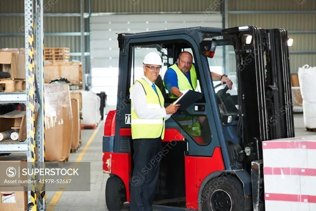 Two warehouse workers standing and smiling while at work