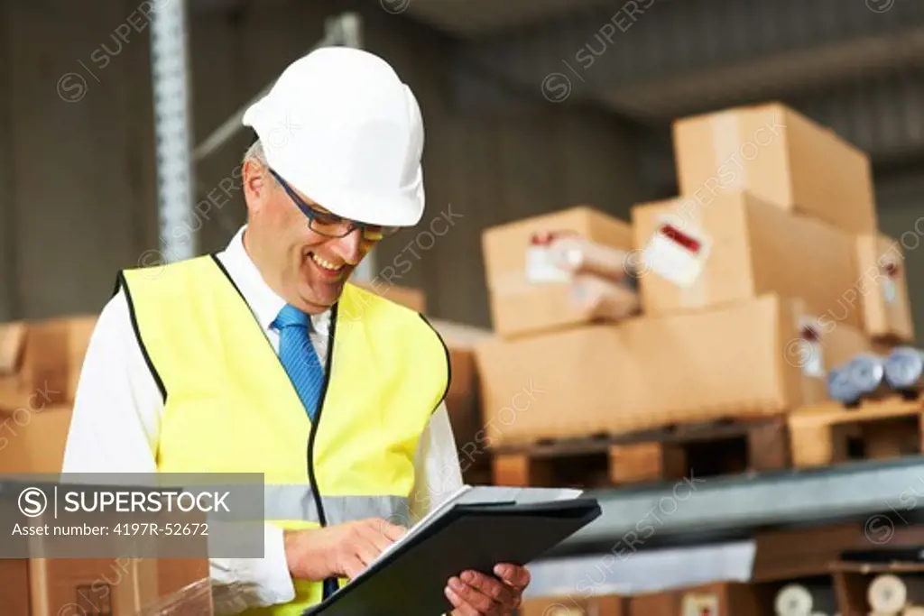 Warehouse foreman smiling while checking his stock