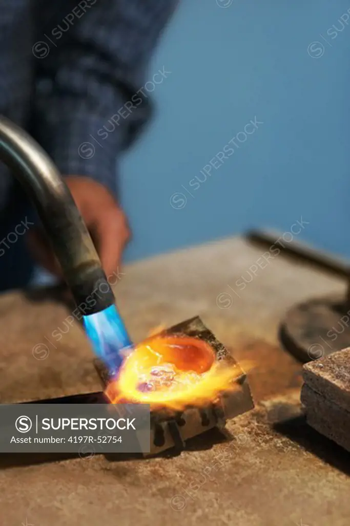 Pretty closeup of a bright flame melting a metal