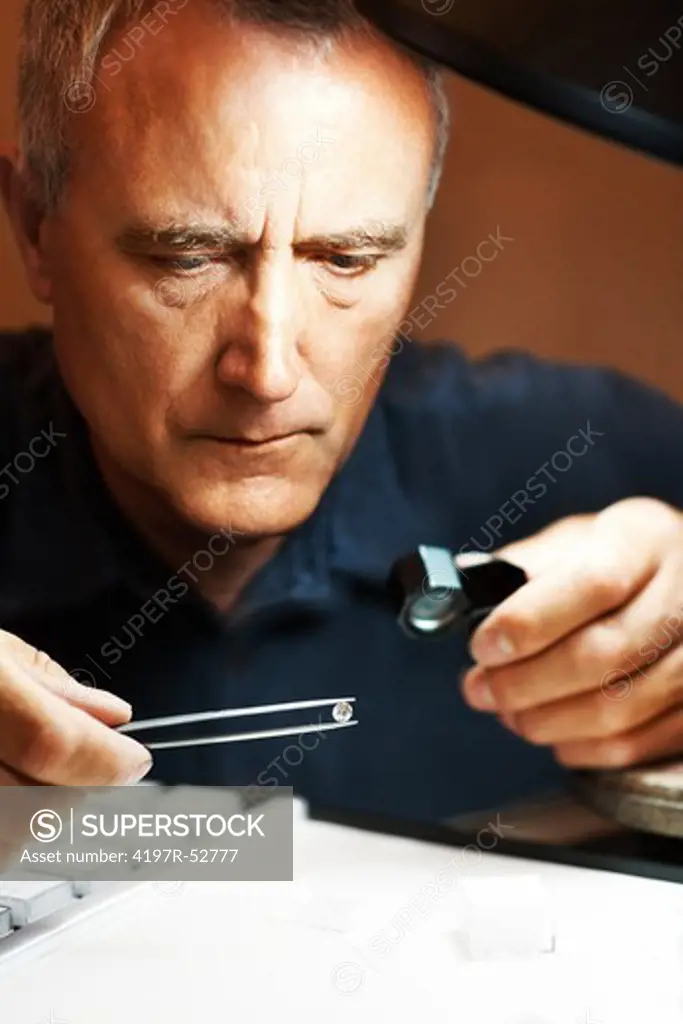 Jeweler looking intrigued at a diamond