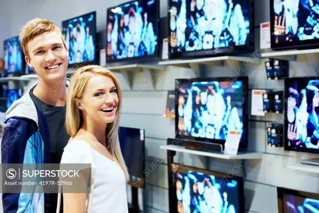 Portrait of happy young couple in consumer electronics store smiling