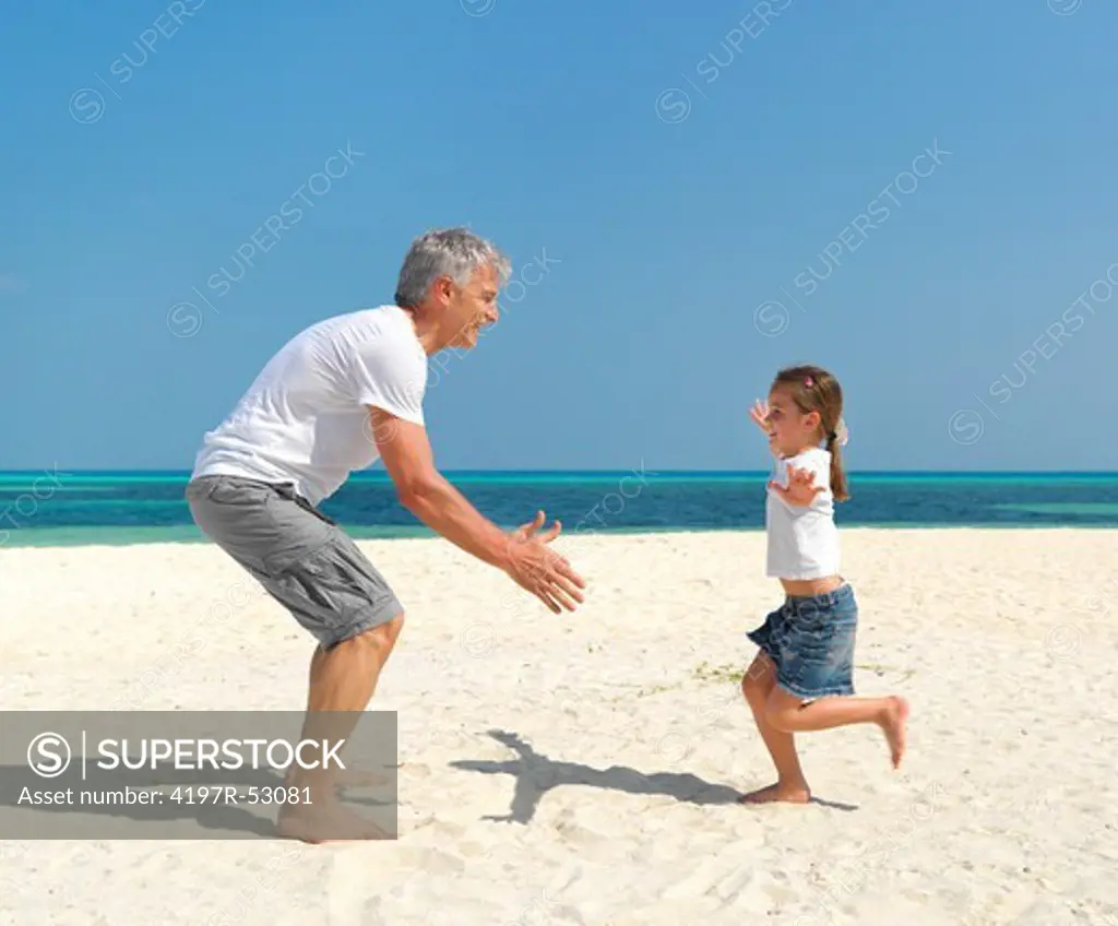 Portrait of cute daughter running into her fathers arms at the beach