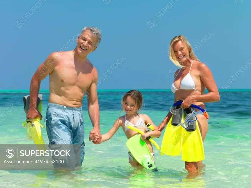Portrait of happy family with their snorkeling gear in the sea having fun