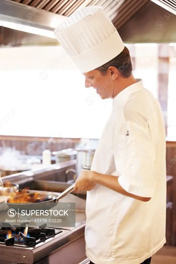 Image of young chef cooking food in restaurant kitchen