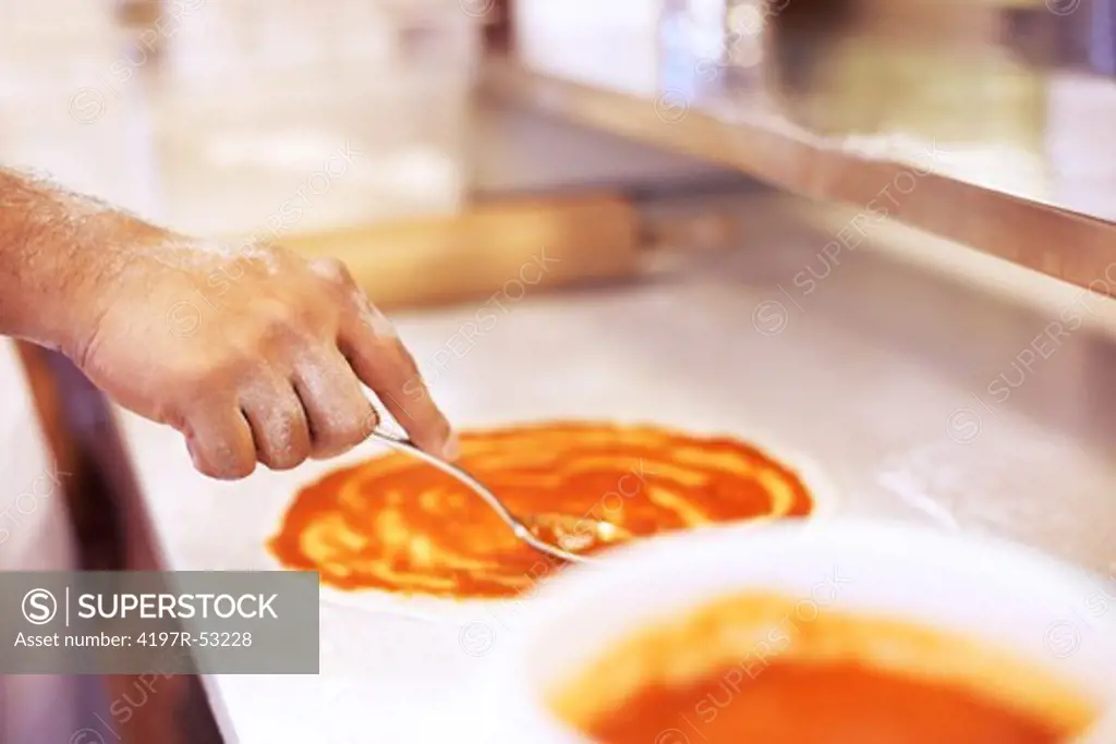Image of pizza being made in restaurant kitchen