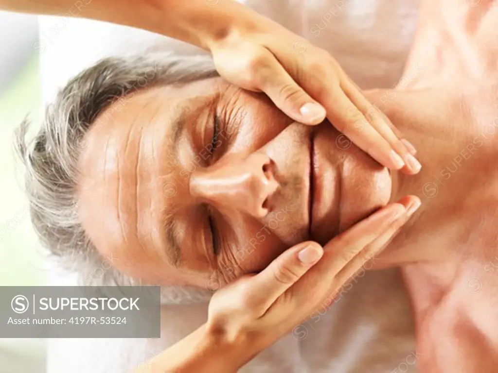 Closeup of mature man getting a face massage at the spa salon