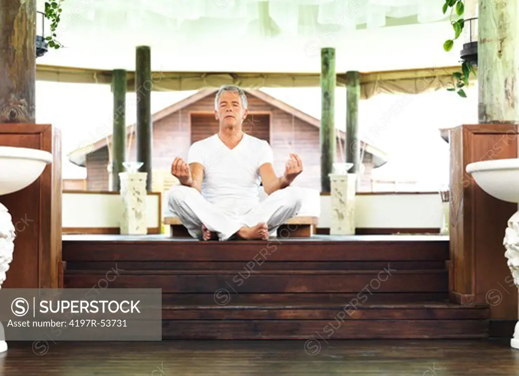 Portrait of mature man meditating at healtcare center