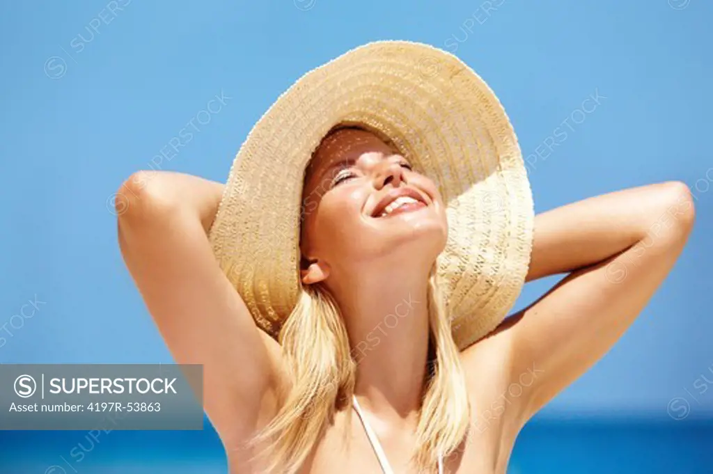 Happy young woman smiling with her eyes closed on the beach